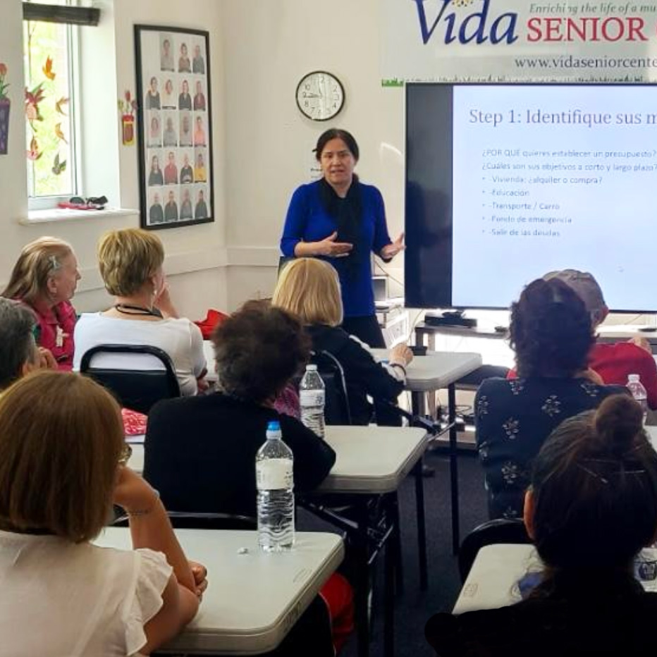Adultos participando en una clase educativa de CENAES con una instructora.